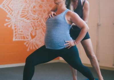 Vanessa Shribman helps pregnant woman get into yoga pose